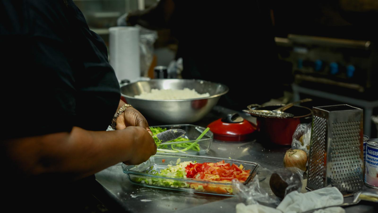 A woman combining seasoning into a glass baking dish.